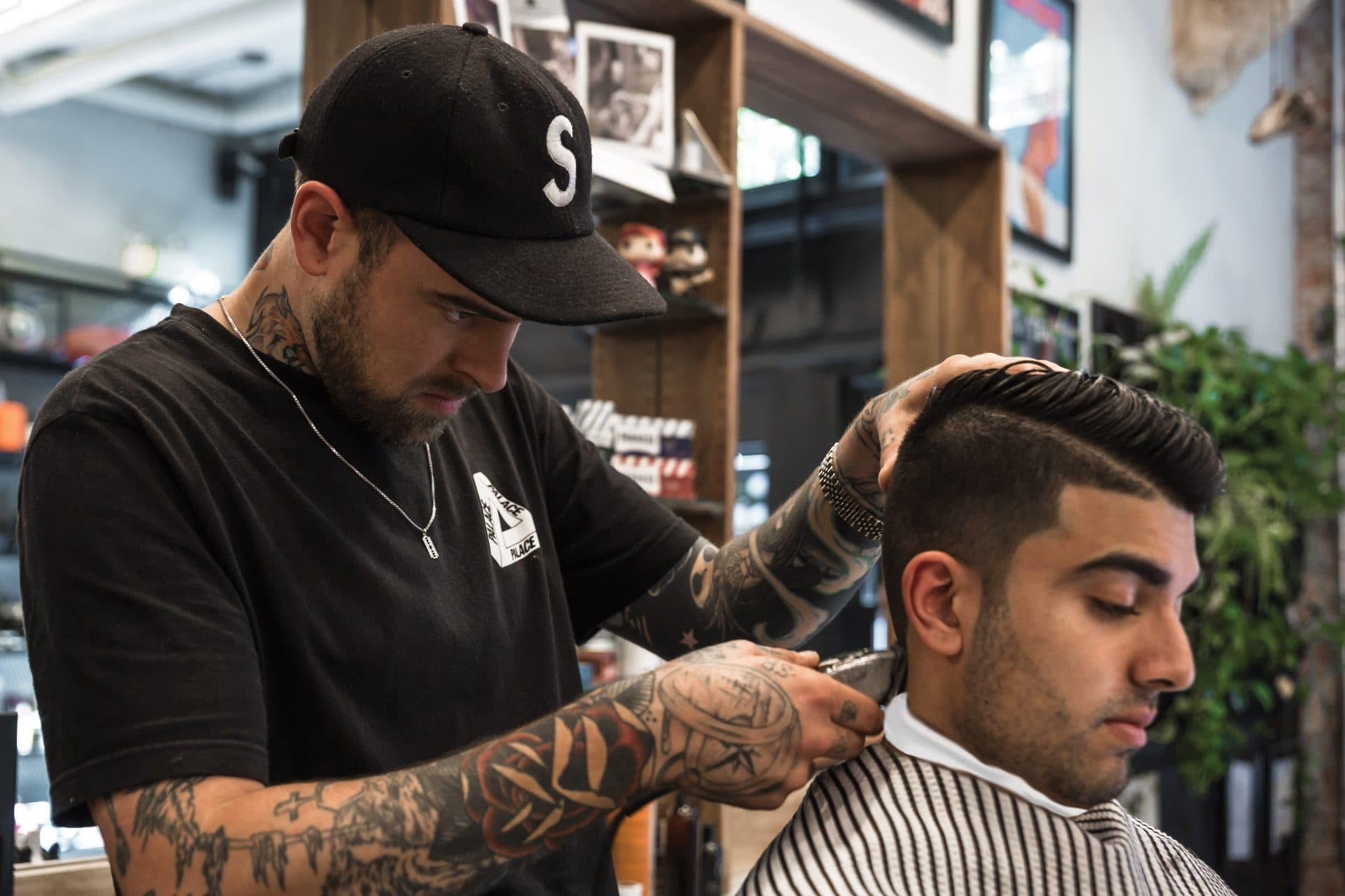 Male barber cutting hair during the Barbering Diploma program at Marca College